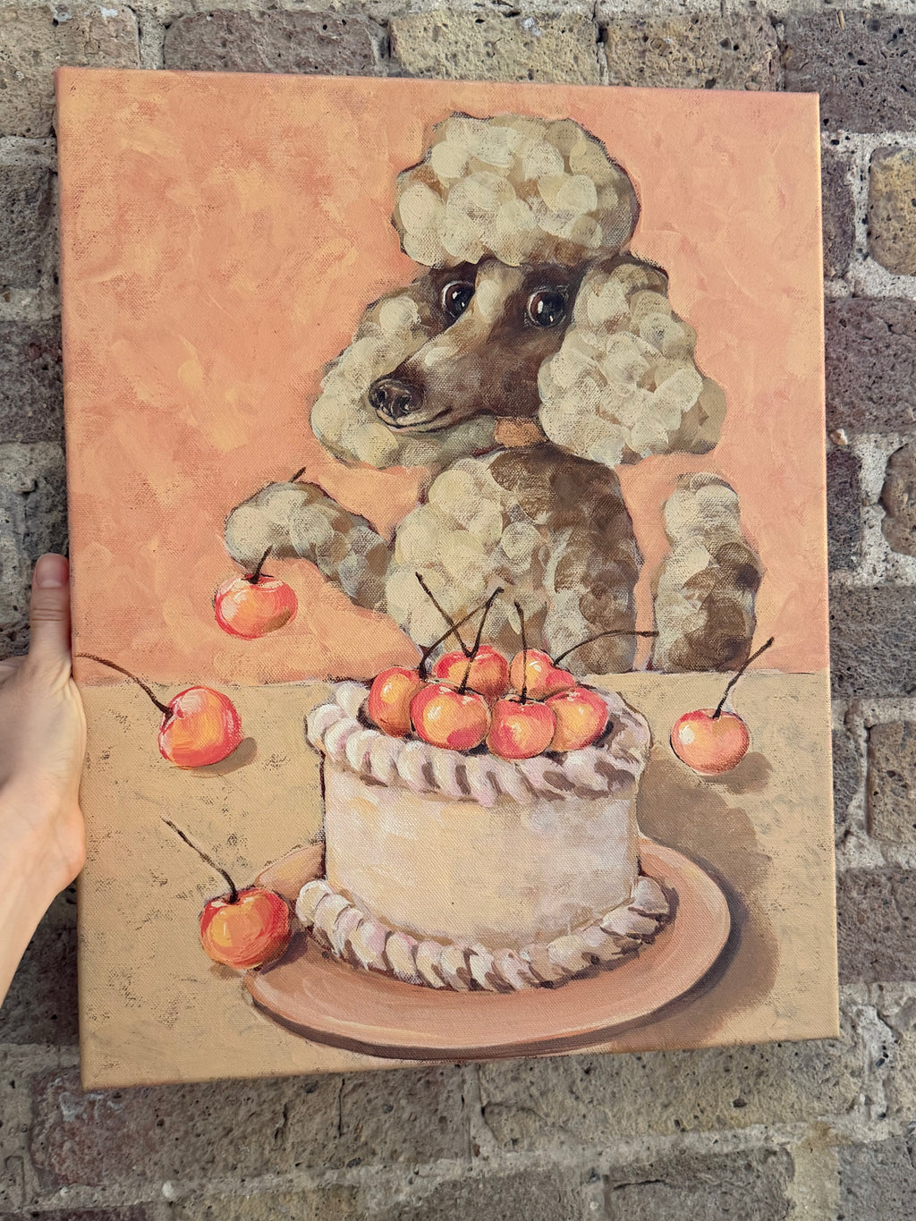 Celebration whimsical dog and cake artwork displayed against a textured brick wall
