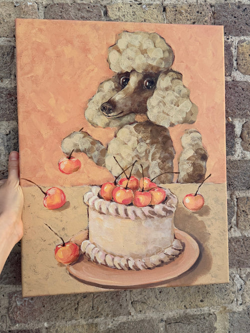 Celebration whimsical dog and cake artwork displayed against a textured brick wall