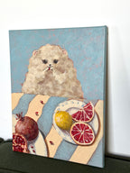 Little Picnic whimsical dog picnic artwork displayed at an angle against a light wall