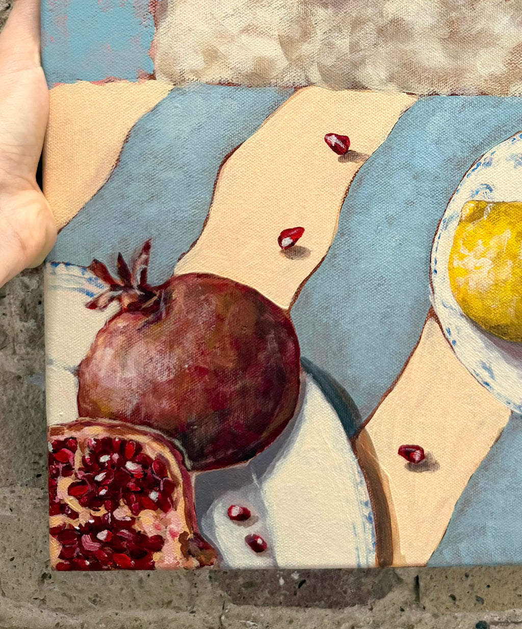Close-up detail of Little Picnic acrylic painting showing pomegranate, citrus fruit and picnic elements