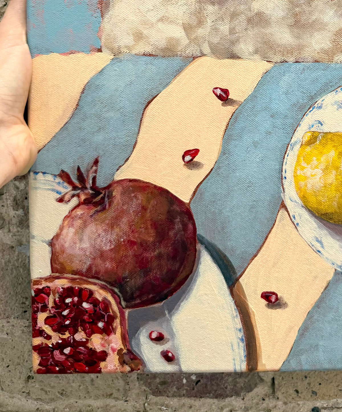 Close-up detail of Little Picnic acrylic painting showing pomegranate, citrus fruit and picnic elements