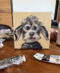 My Dear Old Friend expressive dog acrylic painting shown on an artist worktable with painting materials