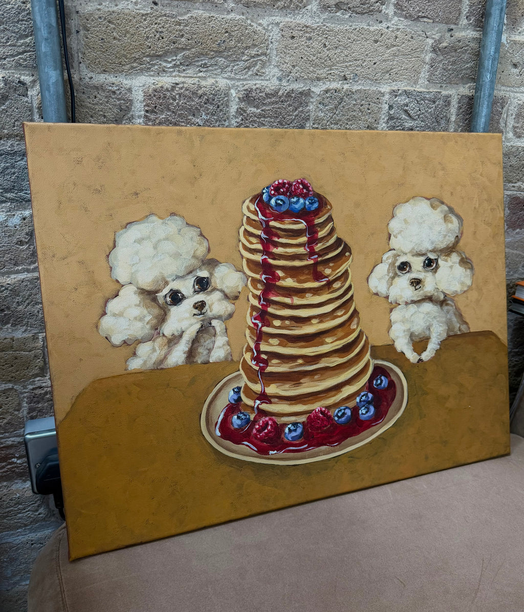 Pancake Day dog acrylic painting displayed against a textured brick wall in a lifestyle setting